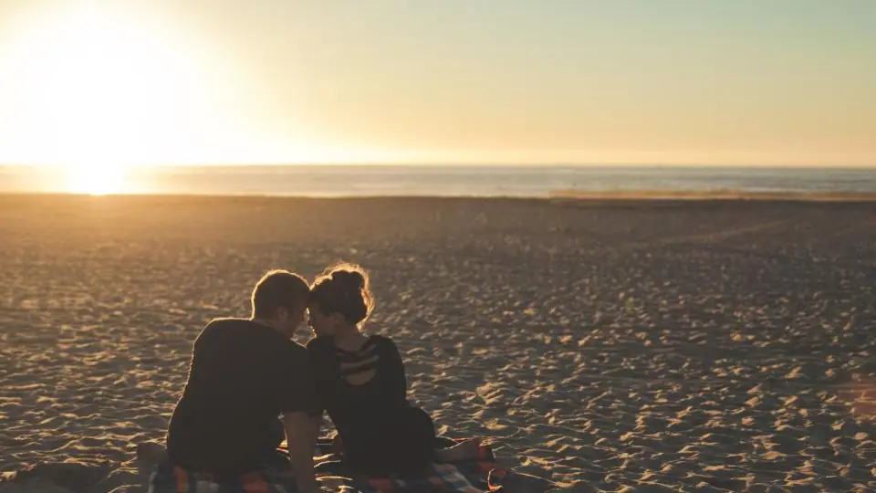 Plan cul Hainaut: un couple assis sur le sable au coucher du soleil